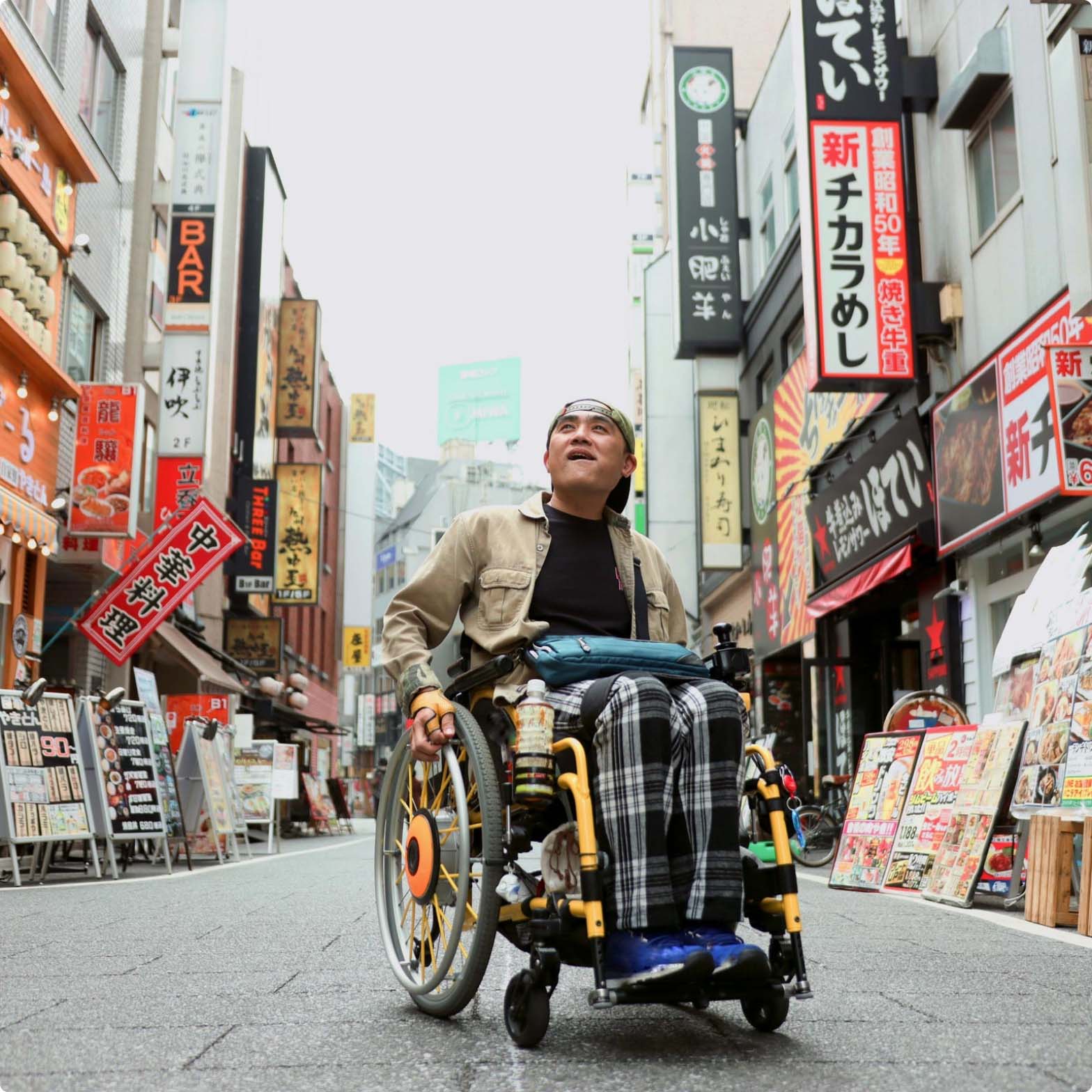 Man in a wheelchair exploring a street in Asia