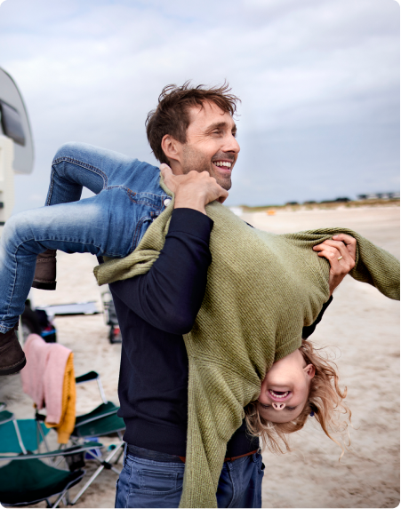 A father and daughter play on the beach
